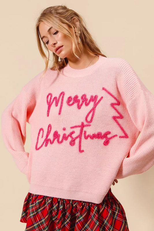 Pink tinsel Merry Christmas sweater with bold lettering, festive women’s holiday pullover knit with long sleeves and ribbed texture