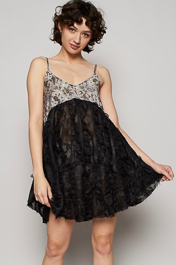 Black babydoll mini with grey floral printed bust, semi-sheer lace skirt, and 3D ruffle texture on a light gray background