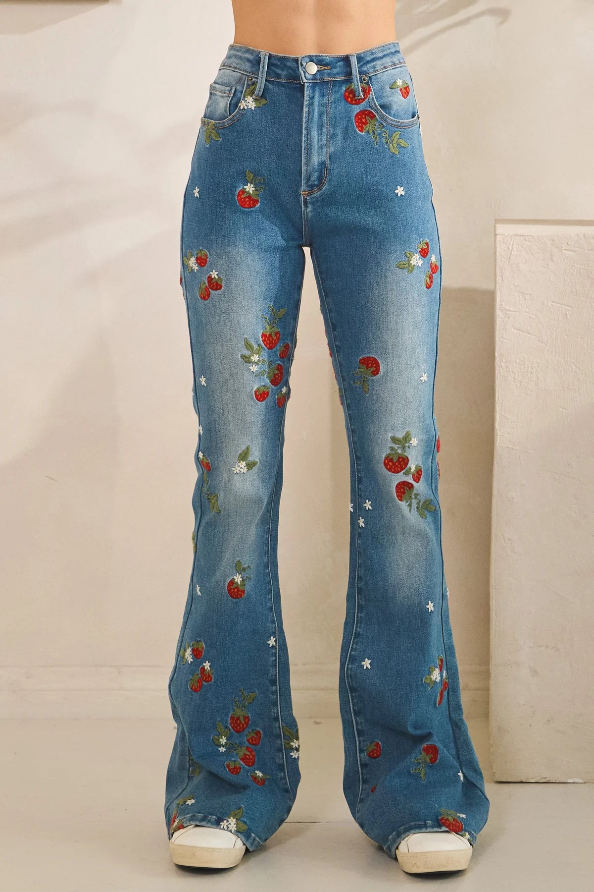 Embroidered flare jeans in dark wash denim with strawberry embroidery, festival ready statement style and relaxed true fit