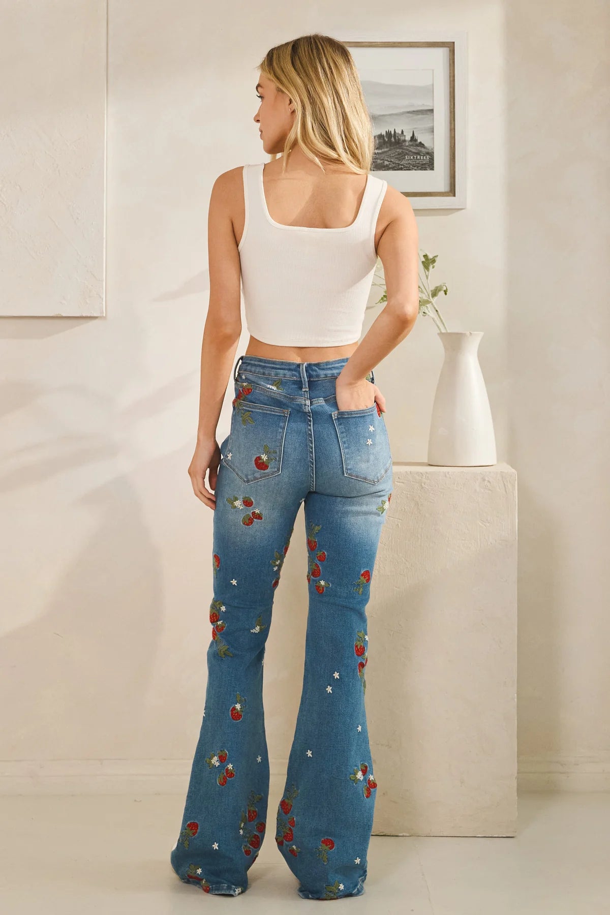 Embroidered flare jeans with strawberry floral embroidery, high rise retro fit, clean finished hems in a feminine boho luxe style