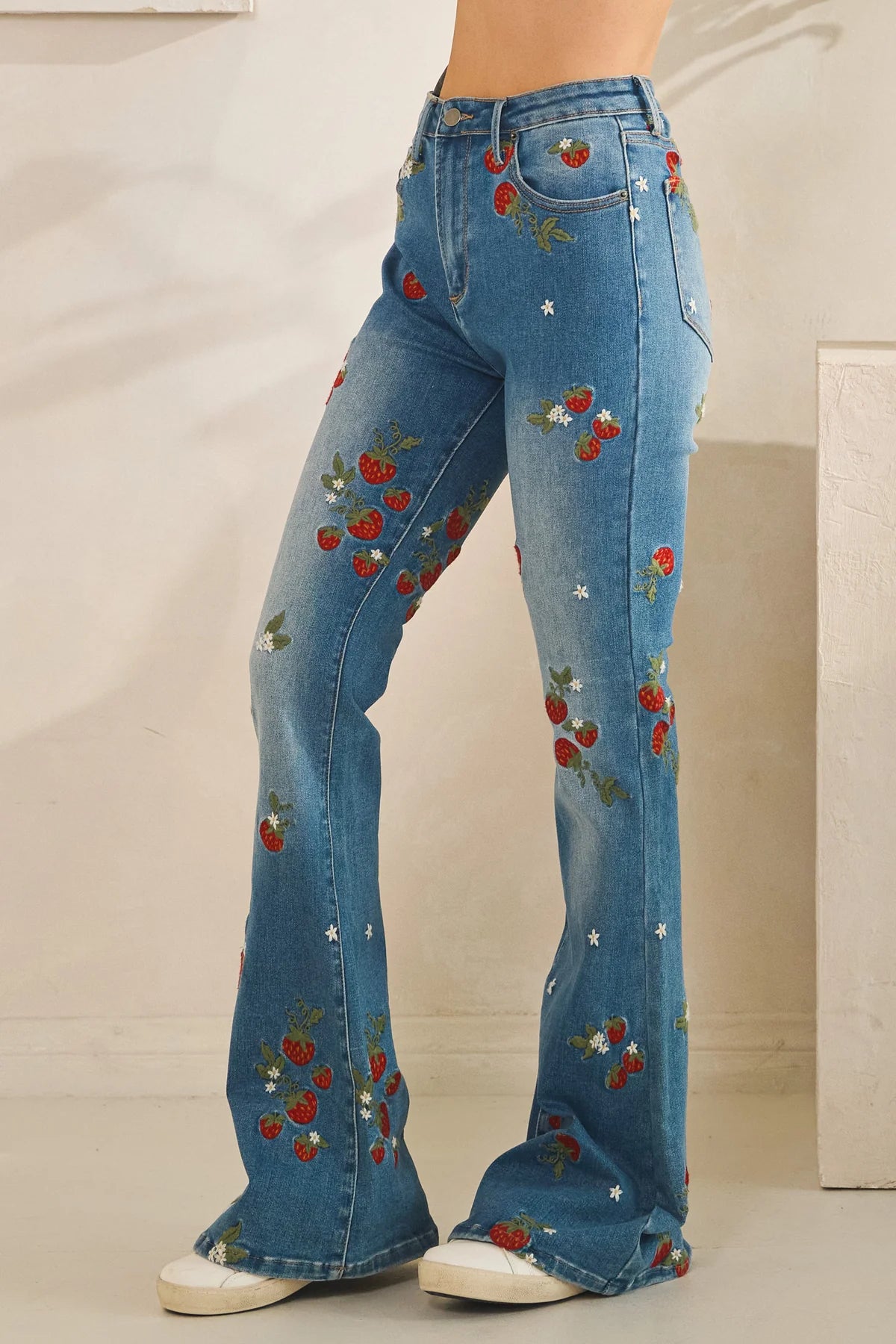 Embroidered flare jeans in dark wash denim with strawberry floral embroidery, retro revival 70s silhouette and comfy stretch