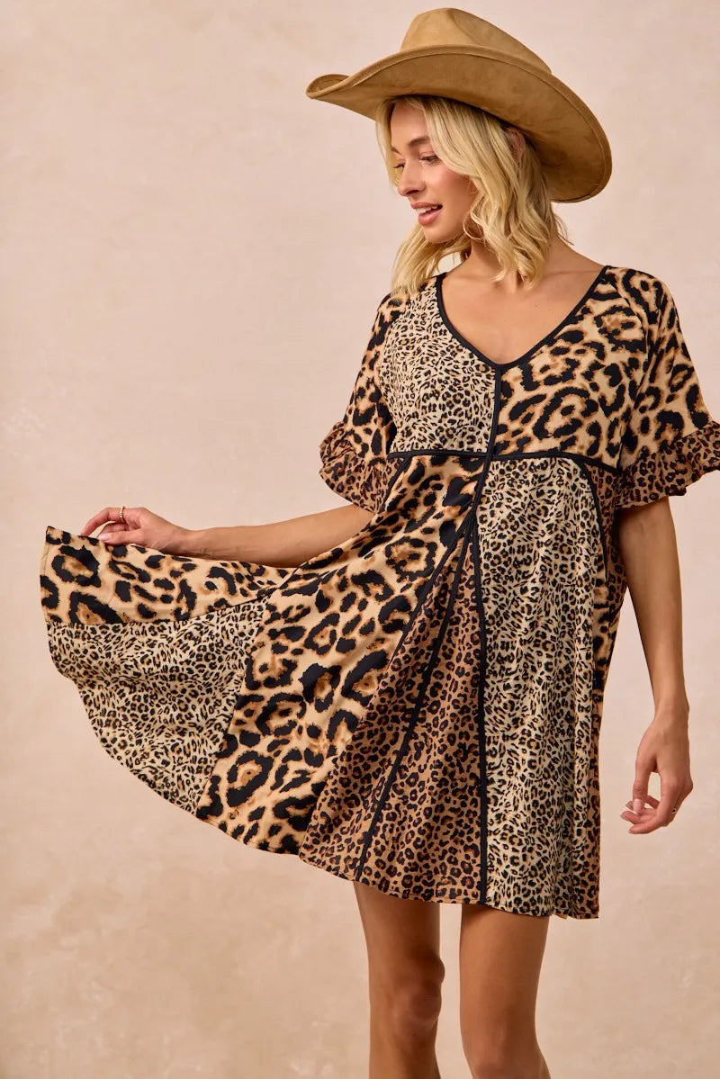 Woman wearing mixed leopard print mini dress with cowboy hat, front view
