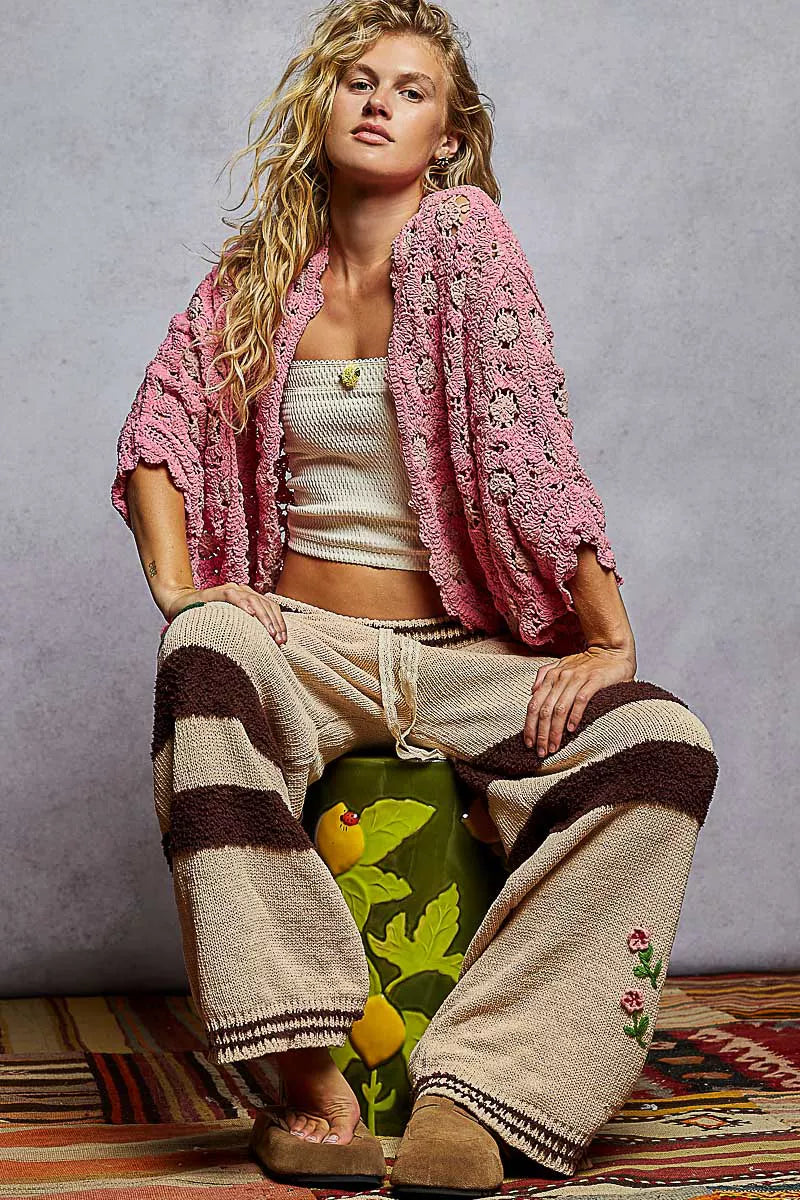 Pink crochet cardigan styled with tube top and comfy pants for casual layered outfit