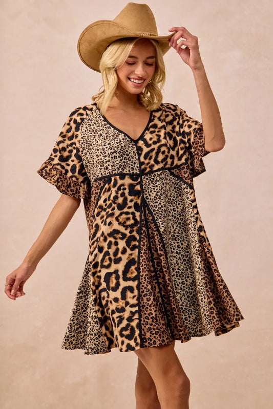 Model in flowy v neck leopard print mini dress, straw western hat and smile