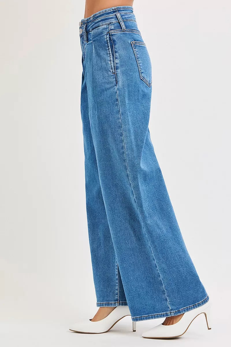 Side view of Risen wide leg pleated jeans styled with heels