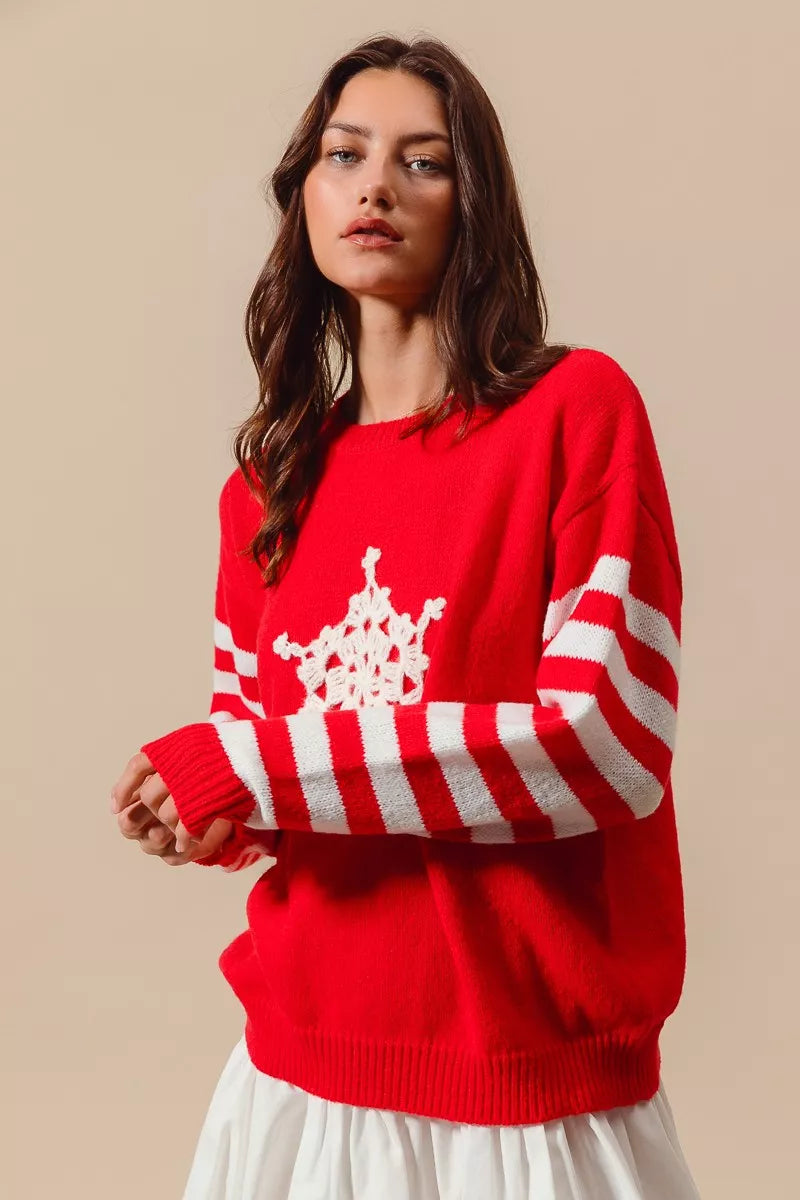 Red oversized sweater with striped sleeves and crochet snowflake patch styled for cozy winter outfit