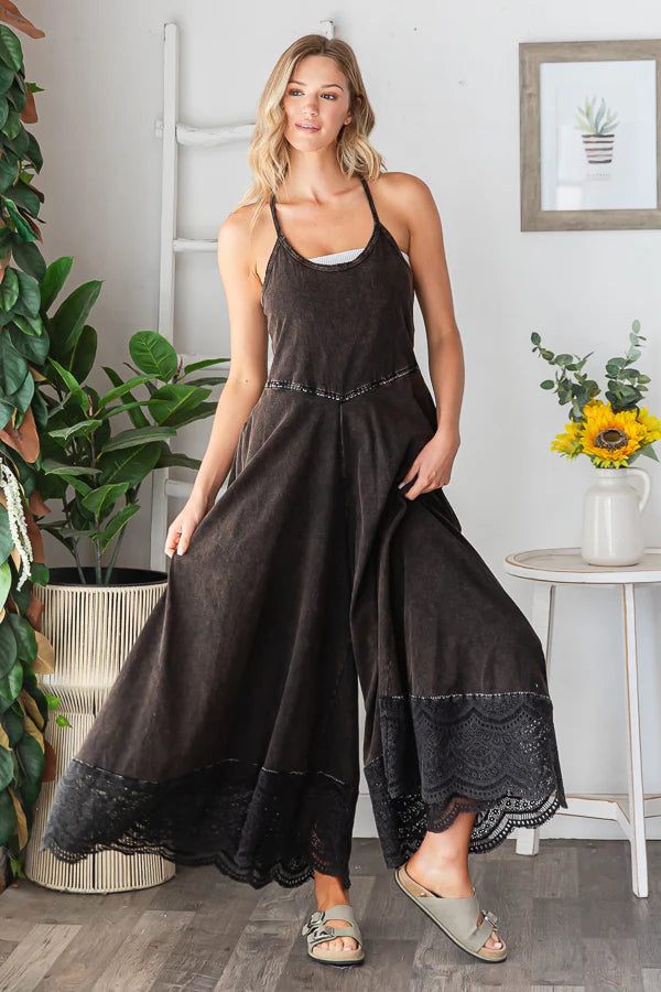 Black cotton wide leg jumpsuit with lace trim, styled on a model in a relaxed boho studio setting.