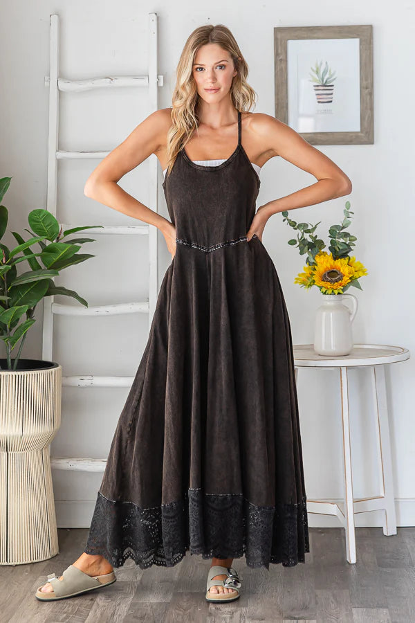 Black wide leg jumpsuit with lace trim, styled on a model in a confident pose, showcasing the fit and flow.