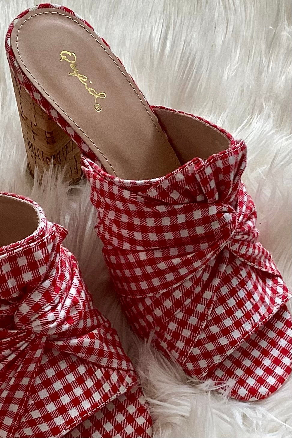 Red white gingham upper close up showcasing the checkered fabric and twist knot detail on a white faux fur rug in natural light
