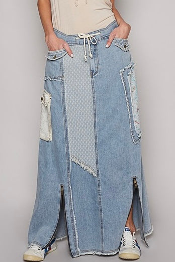 Relaxed fit med Wash denim maxi skirt. Button & zip closure with drawstring, cargo button flap pockets, mixed fabric patchwork, floor length with 2 front zipper kick pleats.