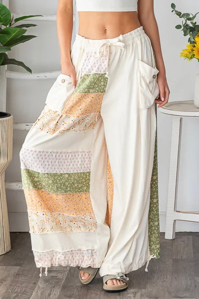 Close-up shot of the Shore Thing Pants in cream patchwork, highlighting the drawstring waist, functional cargo pockets, and mixed patchwork details on the wide leg.
