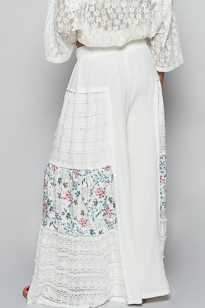 Back studio view of Sunspell Flares, clearly showing the elastic waistband, the relaxed fit, and the floral patchwork and lace panel details on the rear of the flared legs.