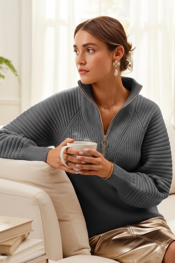 Charcoal gray rib knit half-zip sweater with raglan balloon sleeves, styled with metallic skirt and coffee mug