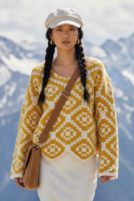 yellow geometric statement sweater with a scalloped hem styled in an alpine scene for a retro inspired cold weather outfit.