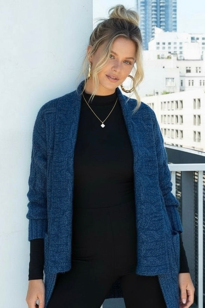 Women’s brushed cable knit cardigan with shawl collar and high low hem, styled as an elevated coastal layer with soft texture and fluid fit.