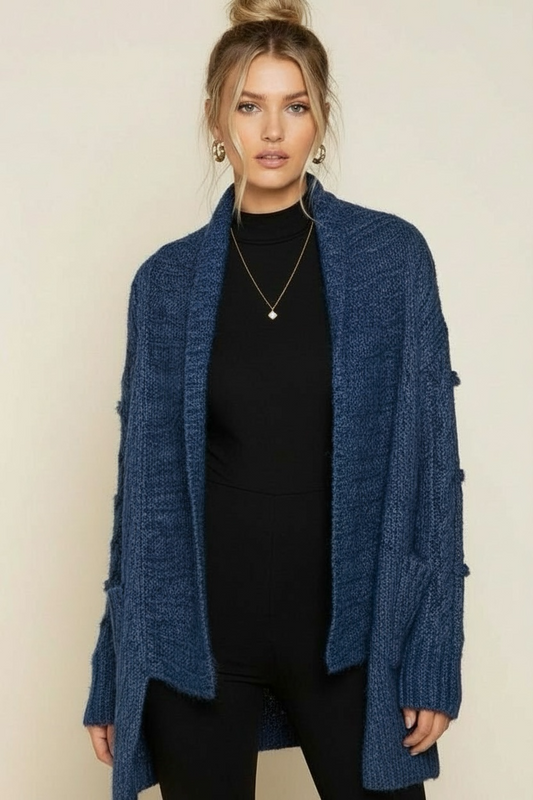 Brushed cable knit shawl collar cardigan in deep ocean blue, shown open front to highlight relaxed drape, side slits, and pocket detail.