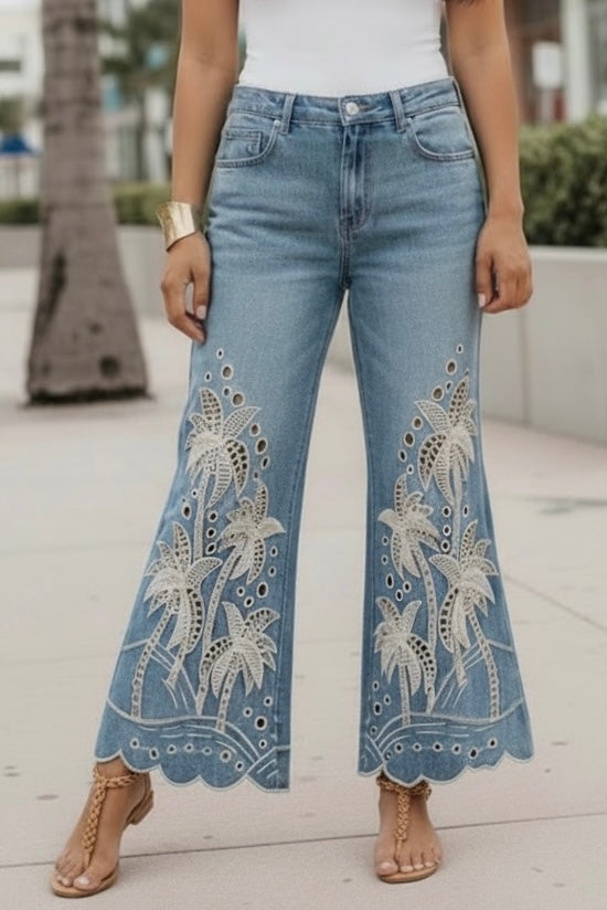 Statement boho embroidered palm tree flare jeans in medium dark mineral wash denim with scalloped hems and tan sandals