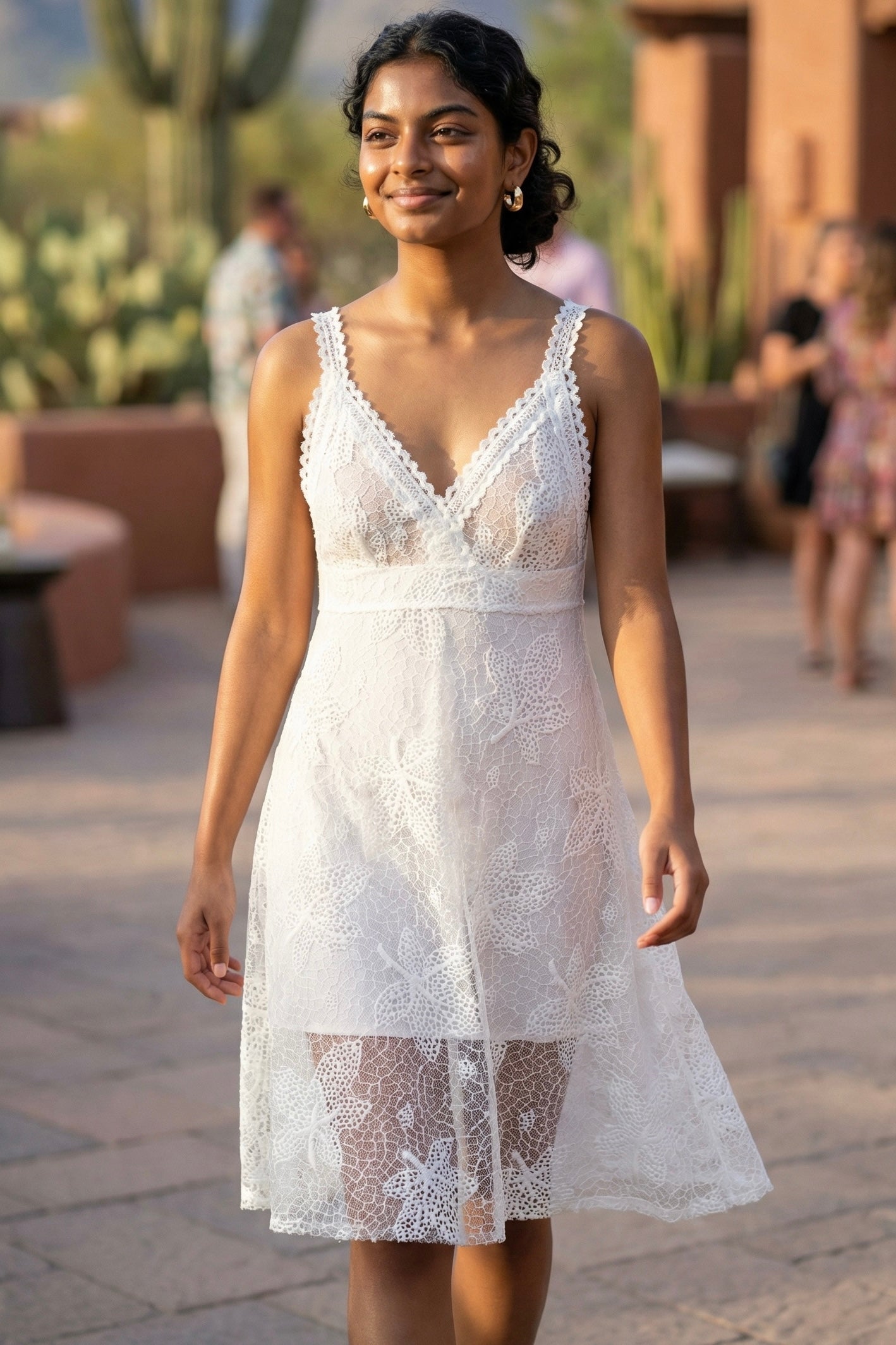 White floral lace plunge neck midi dress with crochet straps, sheer floral lace overlay, and fitted bodice at a desert resort