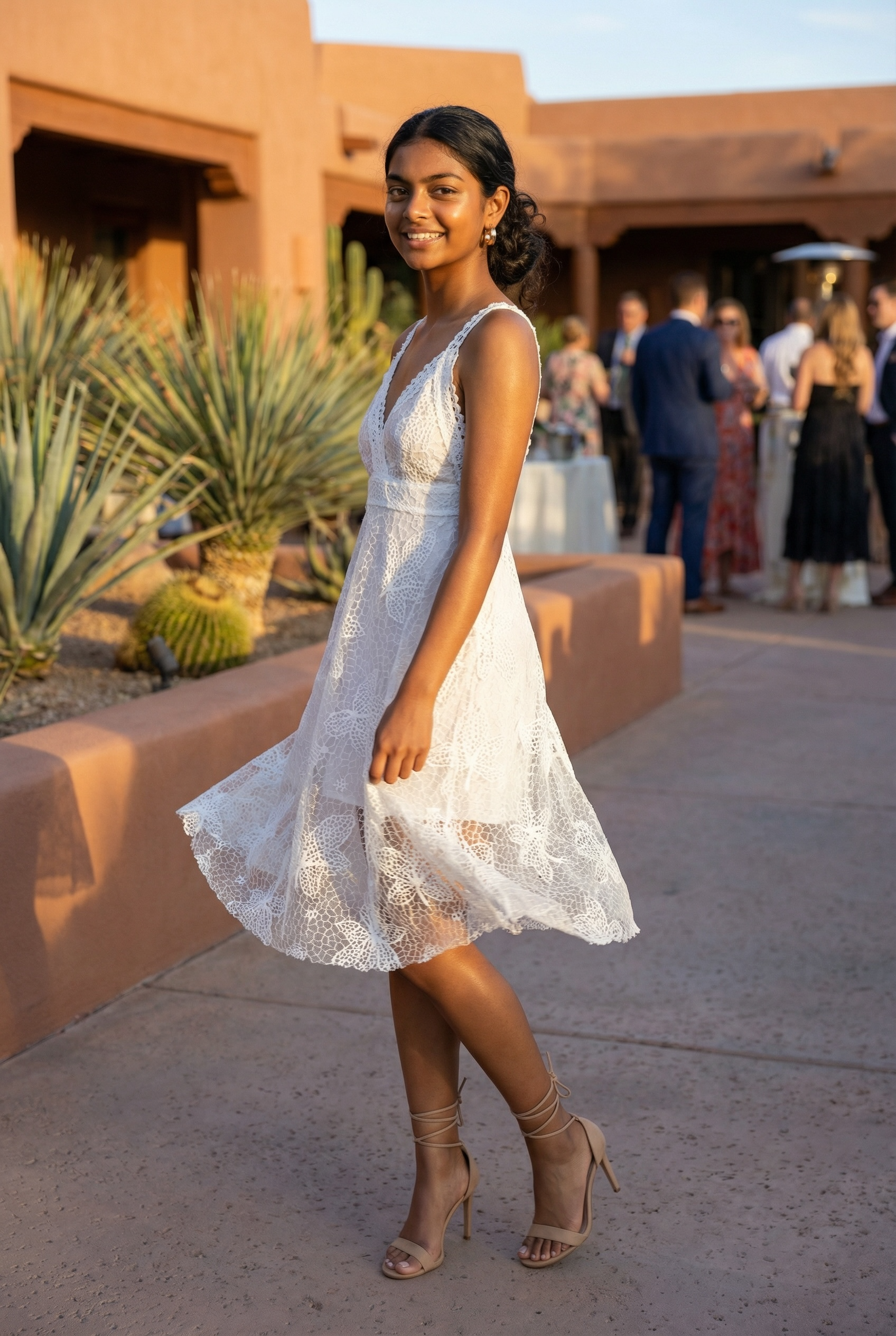White floral lace plunge neck midi dress twirling at golden hour with flowing lace skirt in a desert courtyard