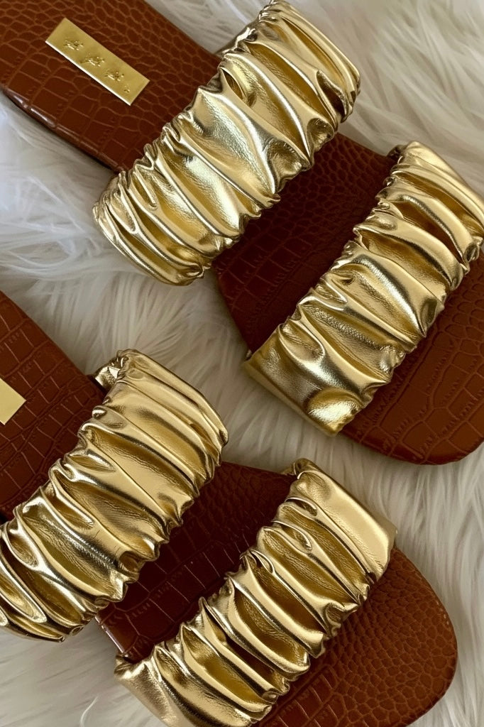 Metallic gold vegan slide sandals close up detail highlighting gathered two strap design and flat croc embossed footbed 