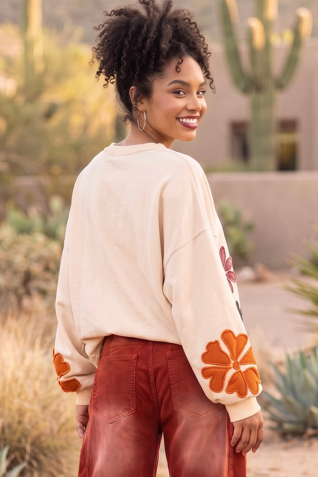 Pullover sleeve with large terracotta orange flower patch and relaxed drop shoulder from the back 