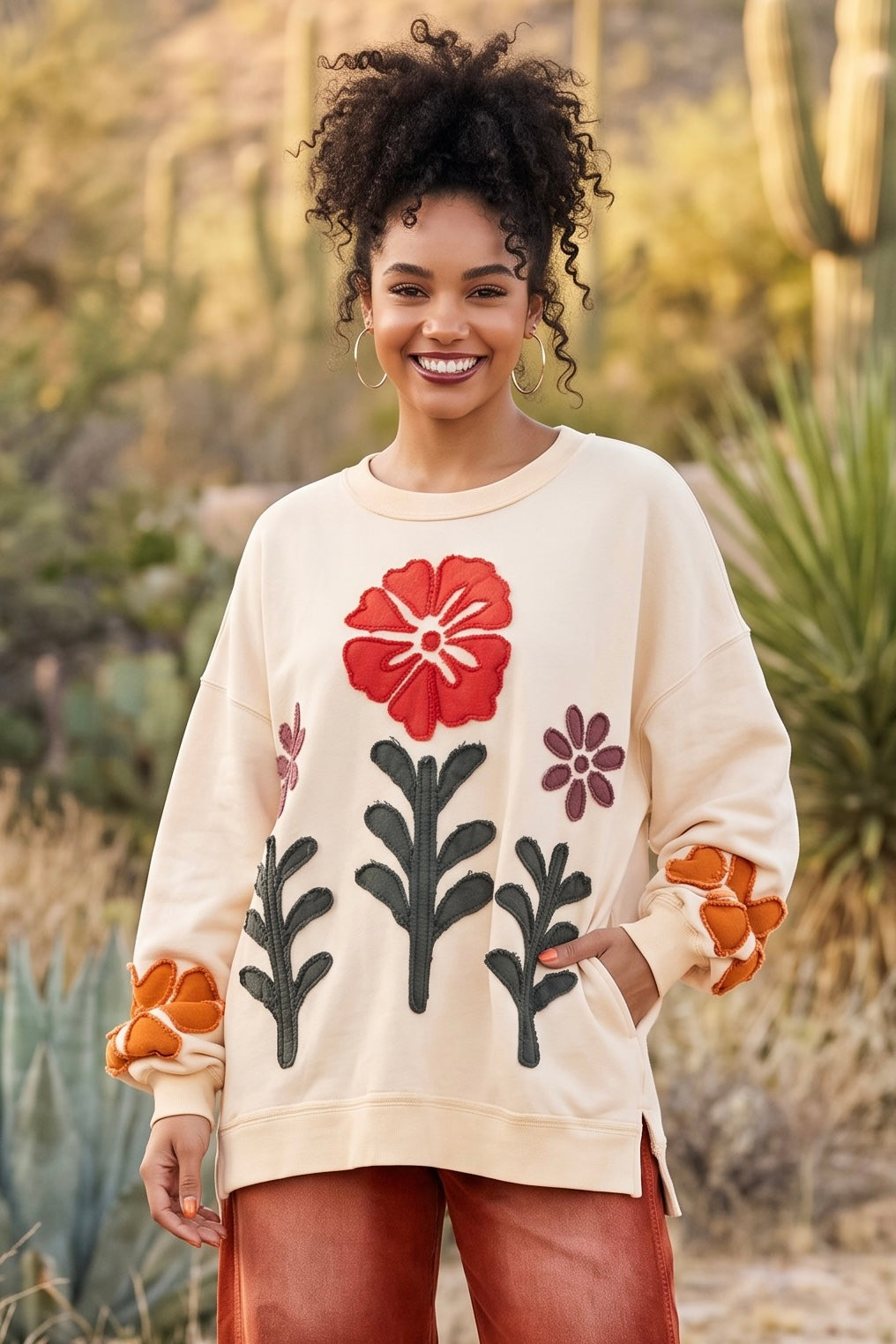Cream cotton french terry sweatshirt with raw bold flower patches and a hand in the side pocket
