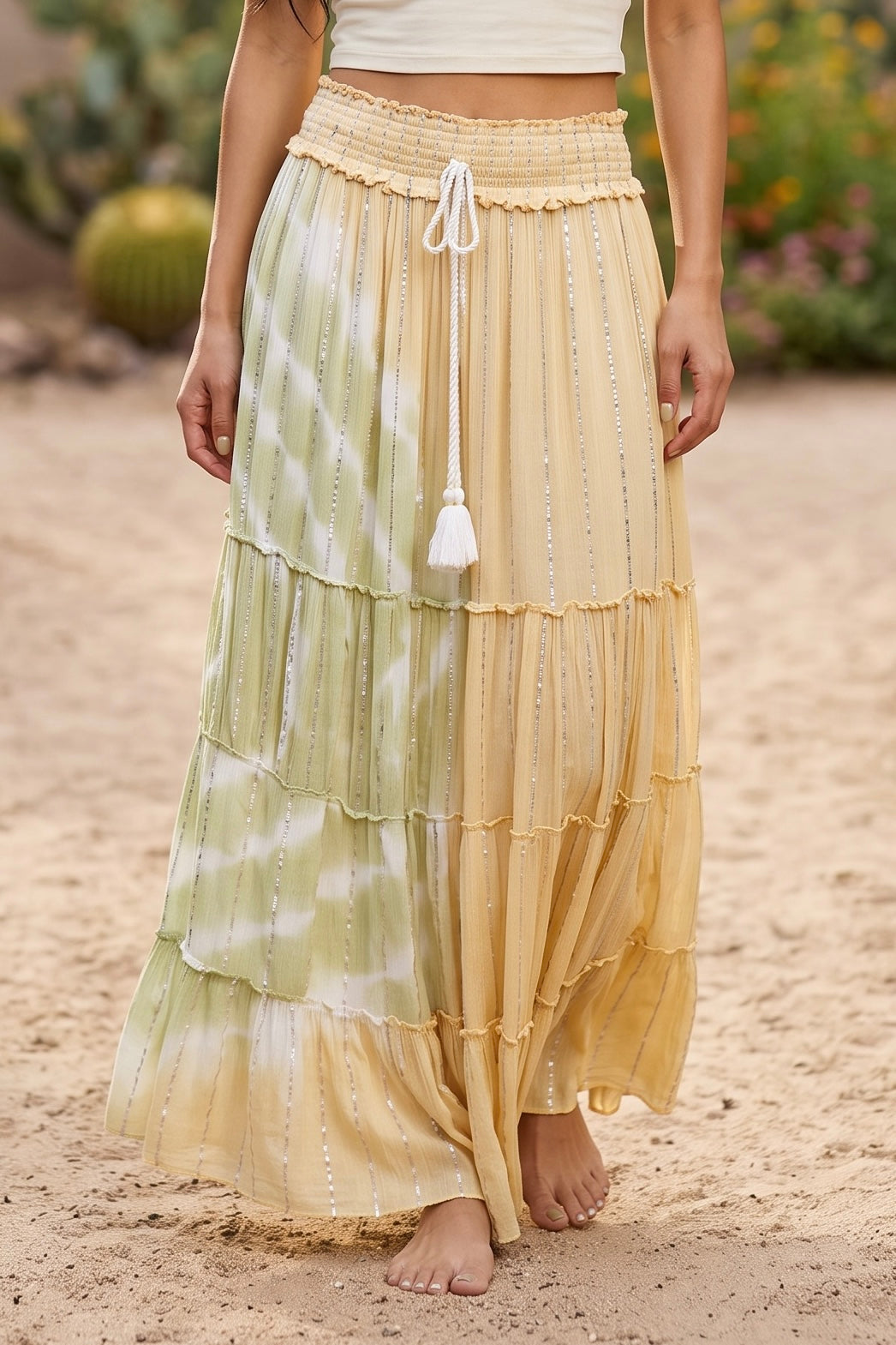 Tiered maxi skirt with smocked waistband, decorative white rope tassel tie and silver stripes on desert sand