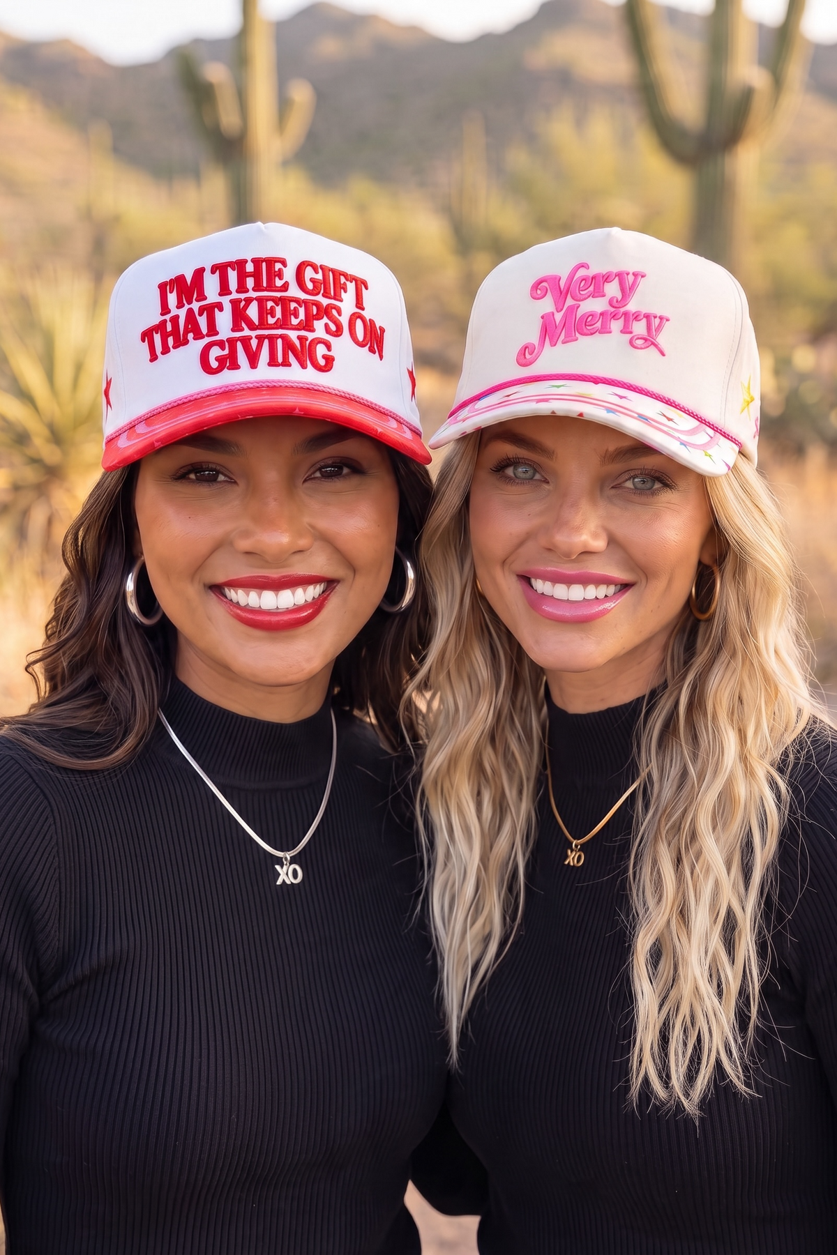 Very Merry hat in cream with pink rope and star brim beside a red lettered Holiday hat,  desert scenery